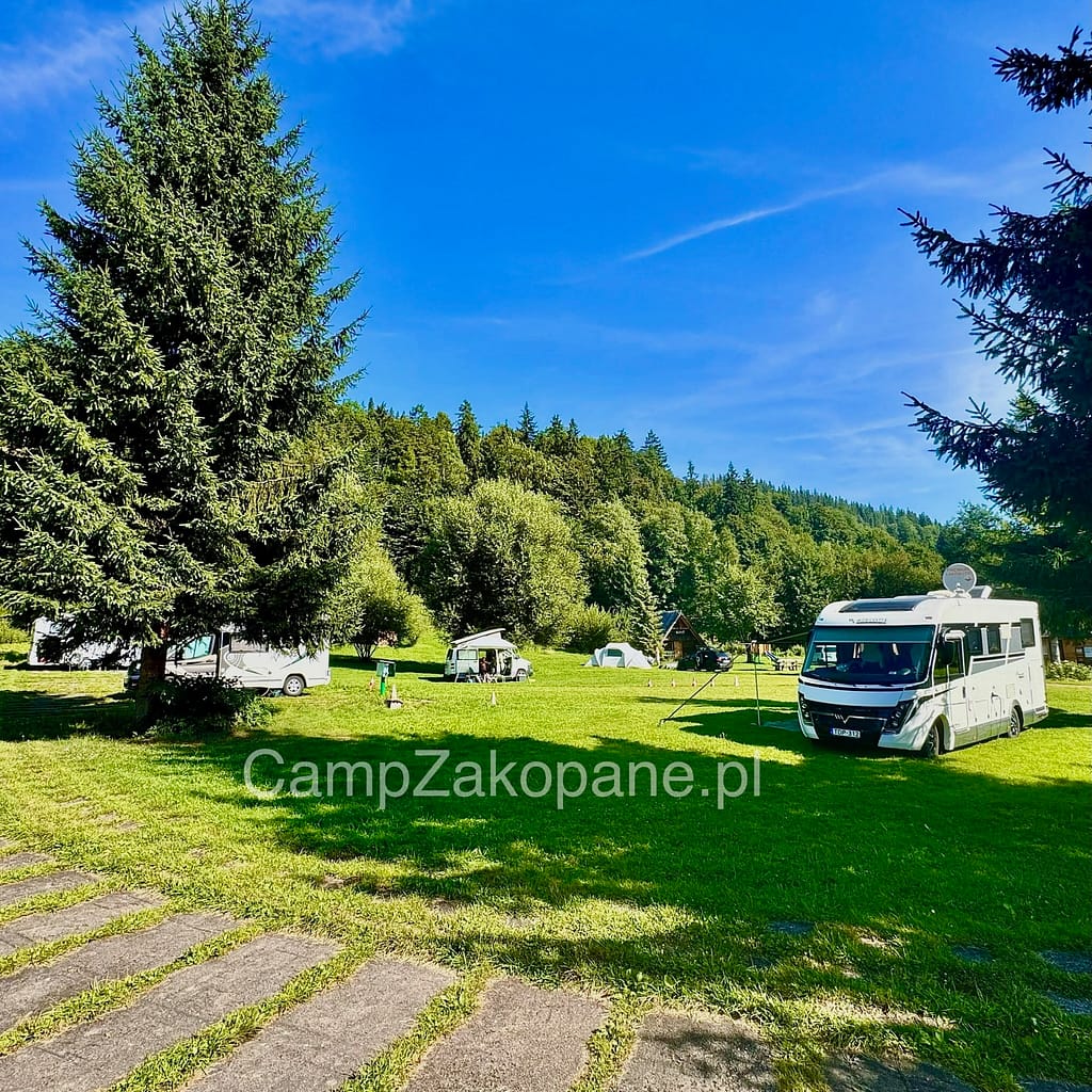 Przestronne pole kempingowe i camper park na Kemping Harenda Zakopane, w otoczeniu gór i lasu.